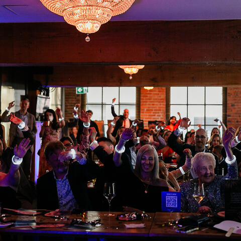 Les invités lèvent leurs bracelets lumineux pendant un moment rassembleur au gala Visionnaires de l’Année.