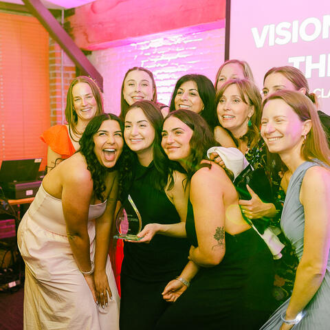 Des participants se réunissent pour une photo souvenir pendant qu’un invité tient un prix lors du gala.